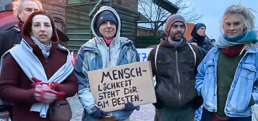 Vier Menschen aus Sieben Linden mit einem Demoschild in der Hand