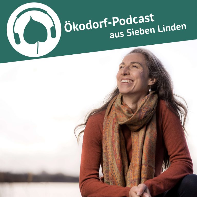 Vivian Dittmar schaut in den Himmel und hat ein breites lächeln im Gesicht. Sie trägt einen organgen Pullover und einen passenden Schal