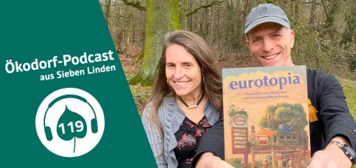 Micha hält die neue Ausgabe vom eurotopia Verzeichnis in die Kamera. Daneben steht Simone
