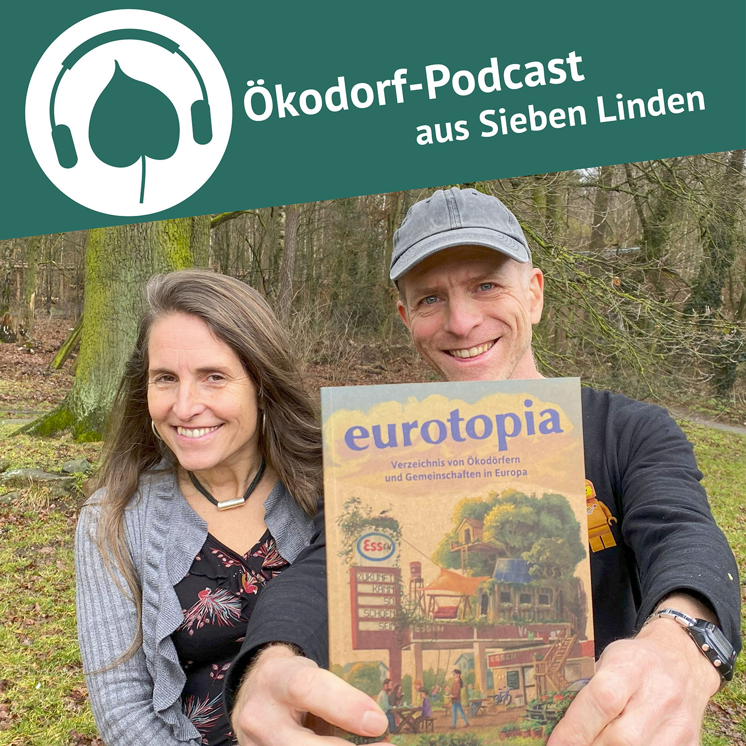 Micha hält die neue Ausgabe vom eurotopia Verzeichnis in die Kamera. Daneben steht Simone
