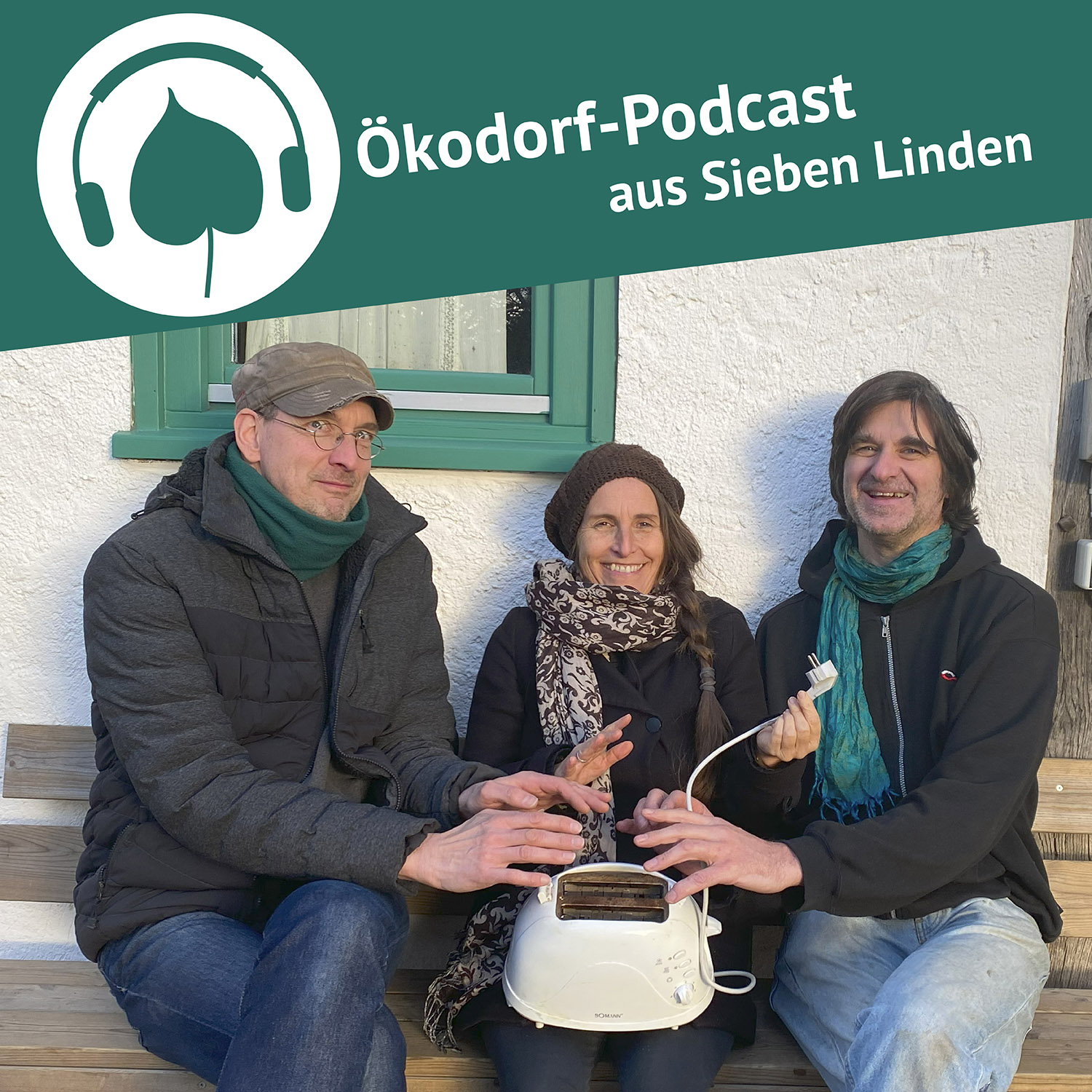 Stefan, Simone und Edi sitzen auf einer Bnk und halten ihre Hände wärmend über einen Toaster, der bei Simone aus dem Schoß steht