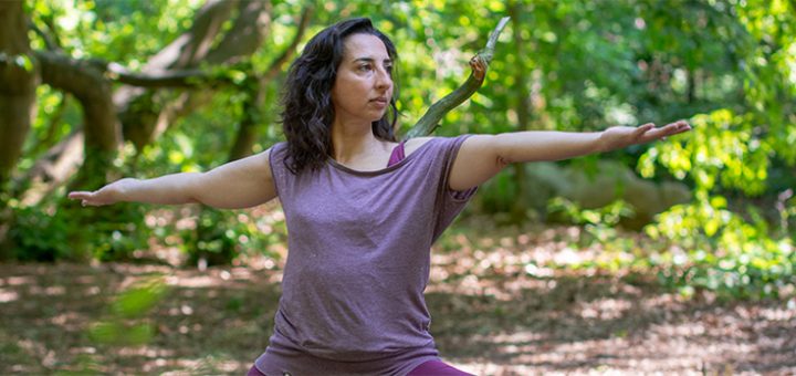 Njana macht eine Yogapose im Wald